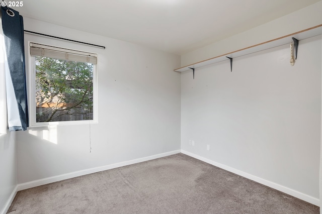 spare room with baseboards and carpet