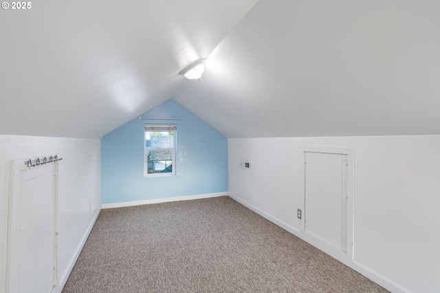 additional living space with baseboards, carpet flooring, and vaulted ceiling