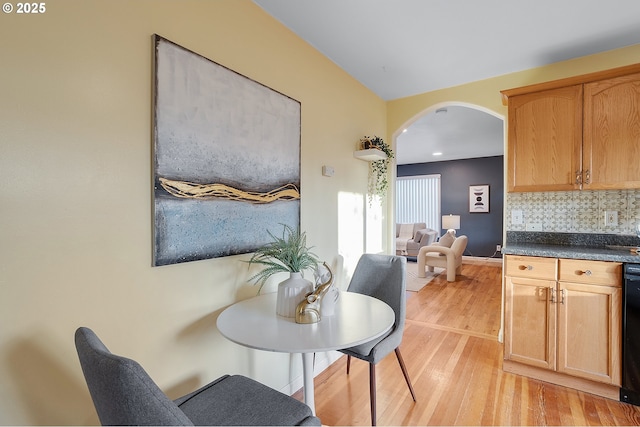 dining area featuring light wood-style floors, arched walkways, baseboards, and recessed lighting