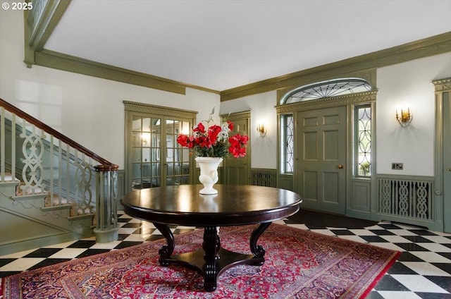 foyer entrance with crown molding and french doors