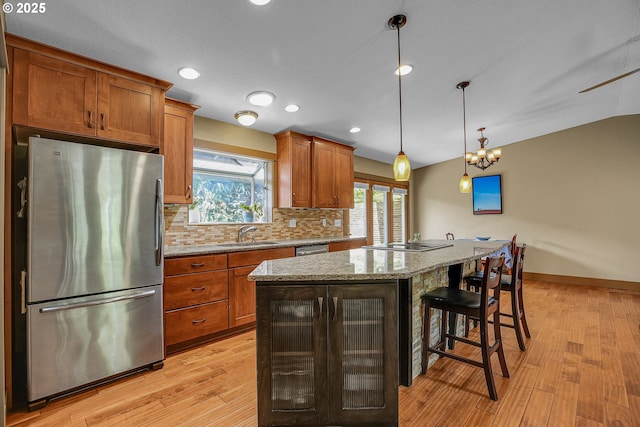 180 NW 107th Ave, Portland, OR 97229 - kitchen with stainless steel appliances, a sink, light wood finished floors, a center island, and a kitchen breakfast bar
