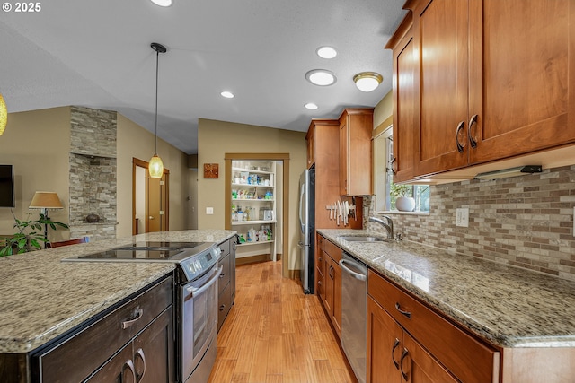 180 NW 107th Ave, Portland, OR 97229 - kitchen with appliances with stainless steel finishes, a sink, light wood-style flooring, tasteful backsplash, and light stone counters