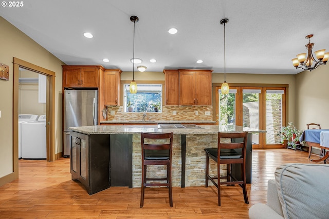 180 NW 107th Ave, Portland, OR 97229 - kitchen featuring a sink, freestanding refrigerator, washer and dryer, decorative backsplash, and healthy amount of natural light