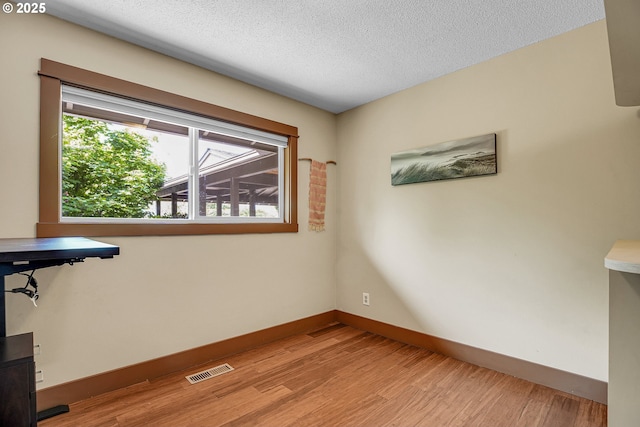 180 NW 107th Ave, Portland, OR 97229 - unfurnished office featuring light wood-style flooring, baseboards, and a textured ceiling