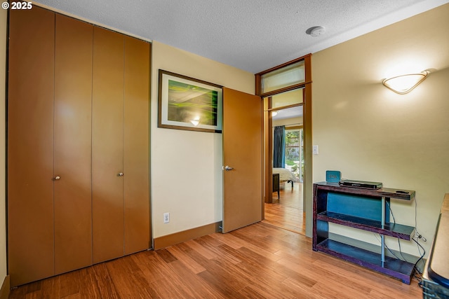 180 NW 107th Ave, Portland, OR 97229 - bedroom with light wood-style floors, a textured ceiling, a closet, and baseboards