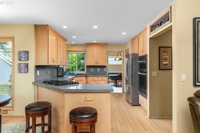13910 SW Secretariet Ct, Beaverton, OR 97008 - kitchen with light brown cabinets, appliances with stainless steel finishes, light wood-style floors, a sink, and recessed lighting