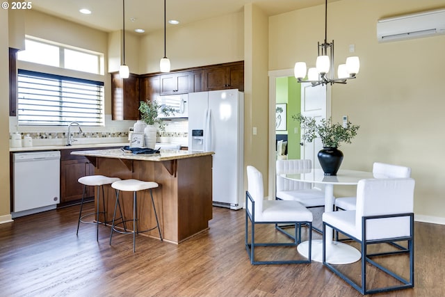 kitchen featuring dark wood-style floors, white appliances, a wall unit AC, and a center island