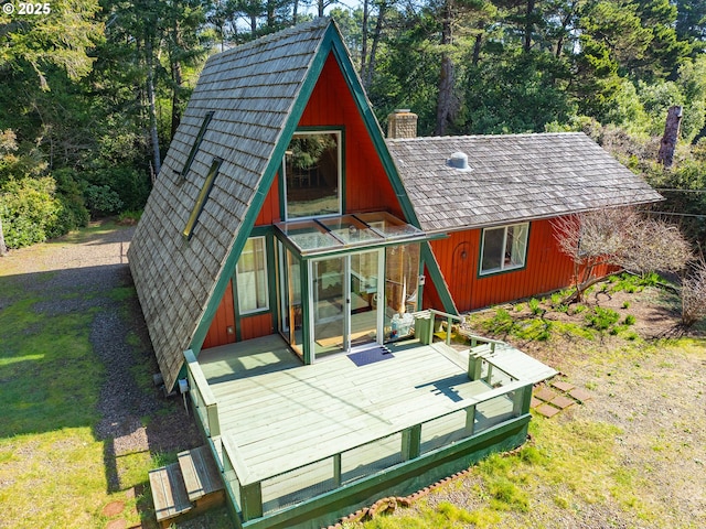 back of property featuring a chimney and a lawn