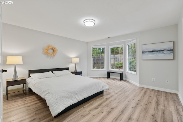 bedroom with light wood-style floors and baseboards