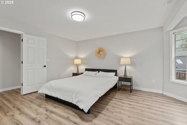 bedroom featuring baseboards and light wood-style floors