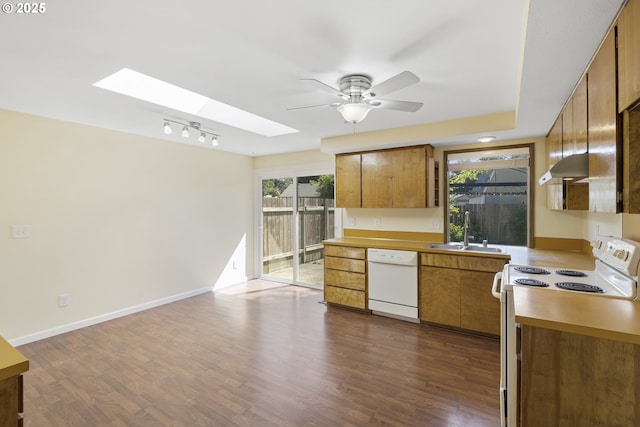 9115 NE Meadowbrook Cir, Vancouver, WA 98664 - kitchen featuring white appliances, a skylight, a ceiling fan, brown cabinets, and wall chimney range hood