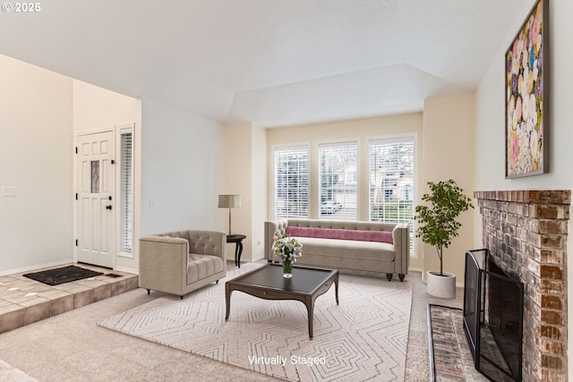 living area featuring a brick fireplace, carpet flooring, and baseboards