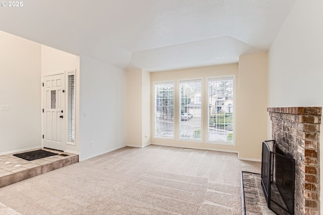 unfurnished living room with lofted ceiling, a fireplace, carpet flooring, and baseboards