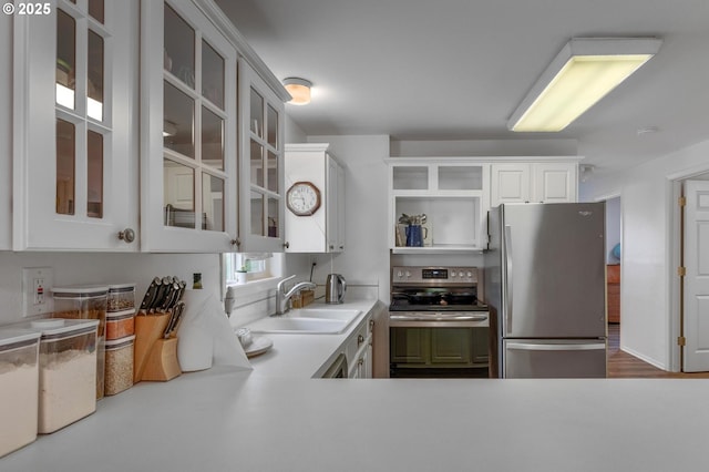 11144 NE Knott St, Portland, OR 97220 - kitchen featuring appliances with stainless steel finishes, open shelves, light countertops, glass insert cabinets, and white cabinetry
