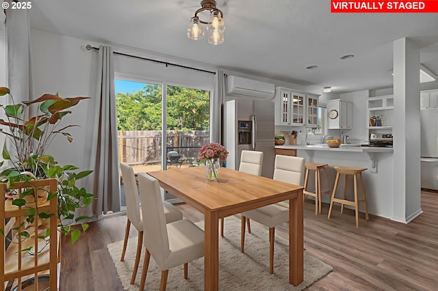 11144 NE Knott St, Portland, OR 97220 - dining space featuring a wall unit AC, wood finished floors, and a chandelier