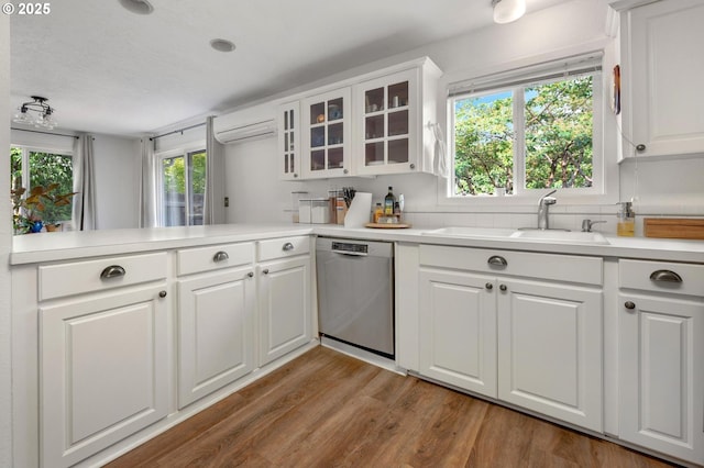 11144 NE Knott St, Portland, OR 97220 - kitchen with stainless steel dishwasher, light countertops, wood finished floors, glass insert cabinets, and white cabinetry