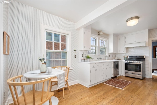 kitchen featuring backsplash, appliances with stainless steel finishes, light wood-type flooring, and white cabinets