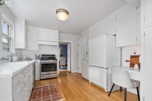 kitchen with white cabinetry, sink, decorative backsplash, stainless steel appliances, and light wood-type flooring