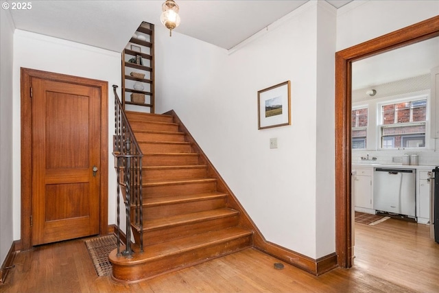 staircase featuring hardwood / wood-style flooring and crown molding