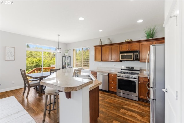 9050 SW 161st Ave, Beaverton, OR 97007 - kitchen with appliances with stainless steel finishes, a sink, brown cabinetry, dark wood-style flooring, and light countertops