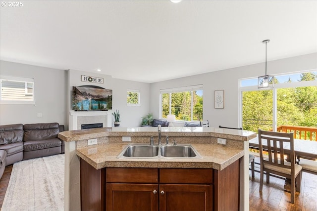 9050 SW 161st Ave, Beaverton, OR 97007 - kitchen featuring open floor plan, a sink, wood finished floors, a fireplace, and decorative light fixtures