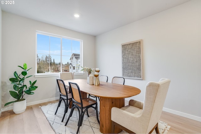 dining room featuring baseboards, recessed lighting, and light wood finished floors