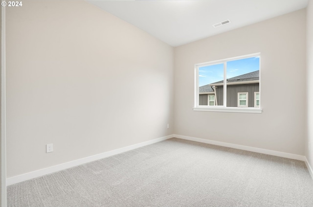 spare room featuring visible vents, carpet, and baseboards