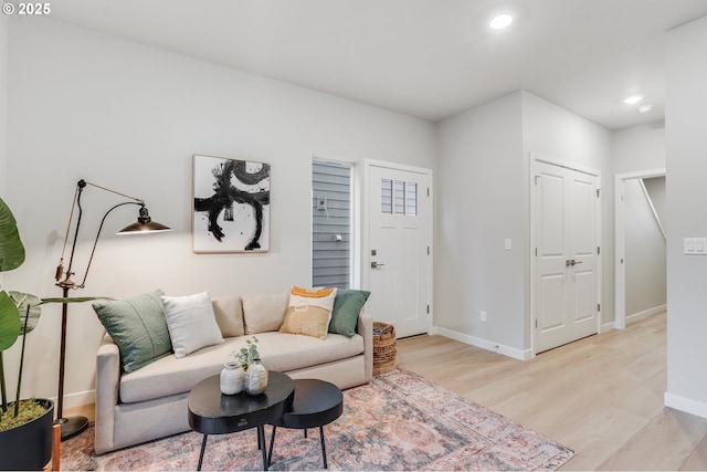 living area featuring recessed lighting, baseboards, and light wood-type flooring