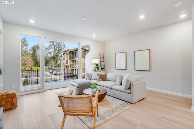 living room featuring recessed lighting, light wood-style flooring, and baseboards