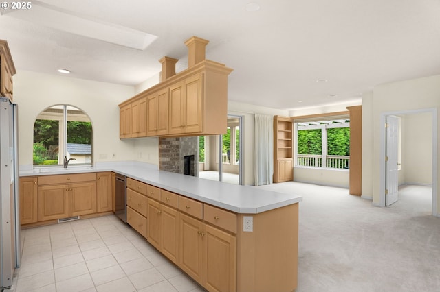 23705 SW Everest Ct, Sherwood, OR 97140 - kitchen featuring stainless steel dishwasher, a peninsula, open floor plan, light countertops, and a fireplace