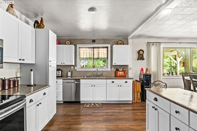 kitchen featuring stainless steel appliances, a sink, dark wood-style flooring, and white cabinetry