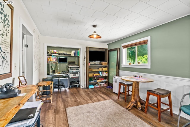 dining space with wood finished floors, an office area, and wainscoting
