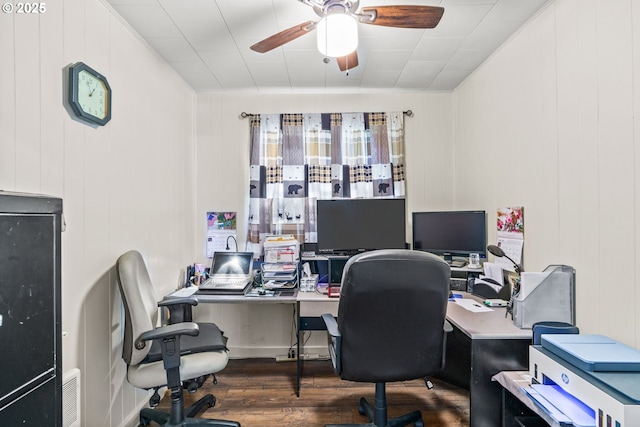 office space featuring a ceiling fan, wood finished floors, and a decorative wall
