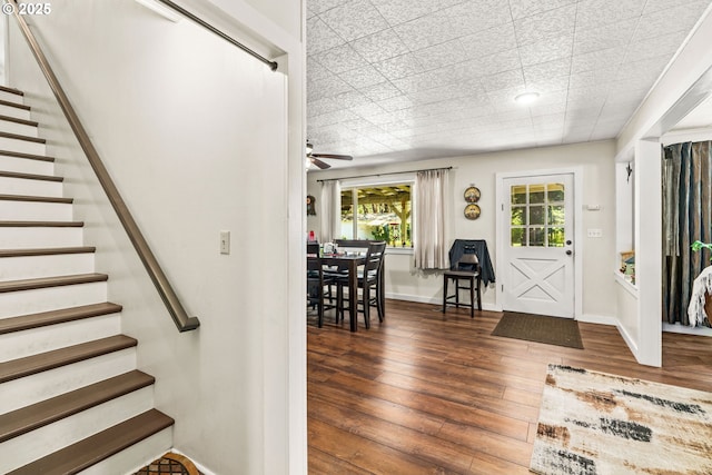 entryway with stairs, wood-type flooring, ceiling fan, and baseboards