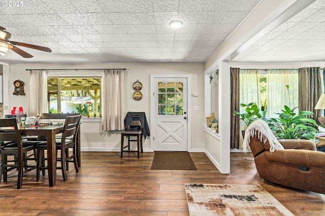 dining space featuring wood-type flooring, plenty of natural light, ceiling fan, and baseboards