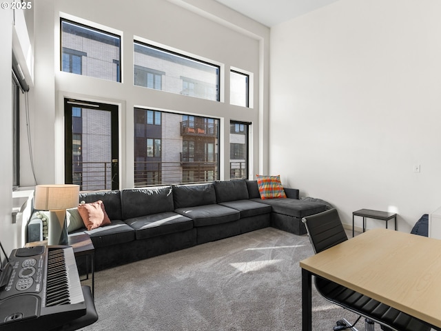 carpeted living room featuring a high ceiling