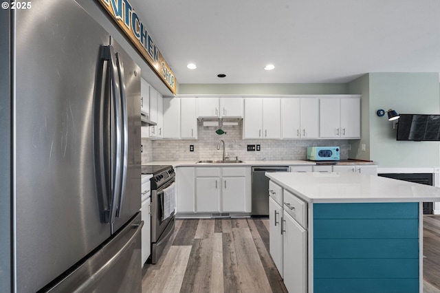 kitchen featuring a sink, decorative backsplash, appliances with stainless steel finishes, and light countertops