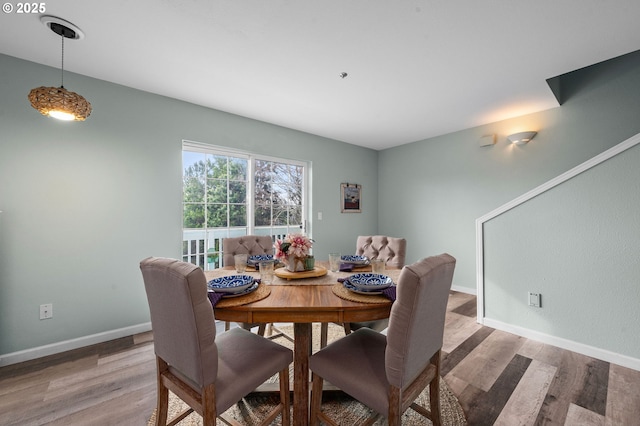 dining area featuring light wood-style flooring and baseboards