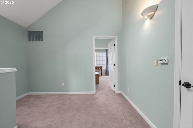 unfurnished bedroom with vaulted ceiling, carpet, visible vents, and baseboards