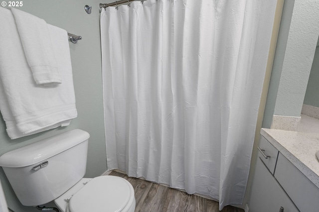 full bathroom with a shower with curtain, toilet, wood finished floors, and vanity