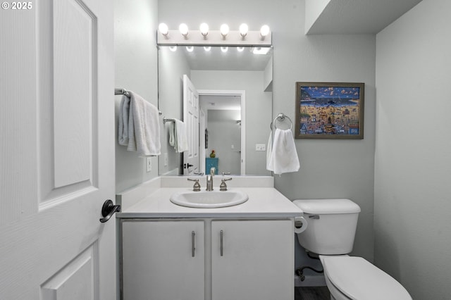 half bathroom with vanity and toilet