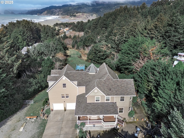 birds eye view of property featuring a wooded view and a water view