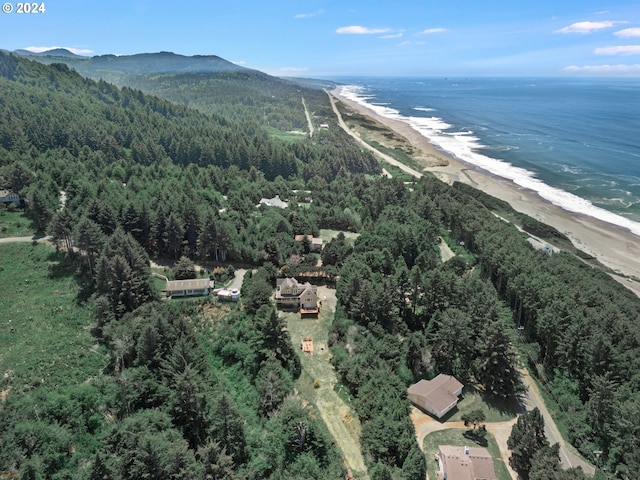 birds eye view of property with a forest view, a view of the beach, and a water view