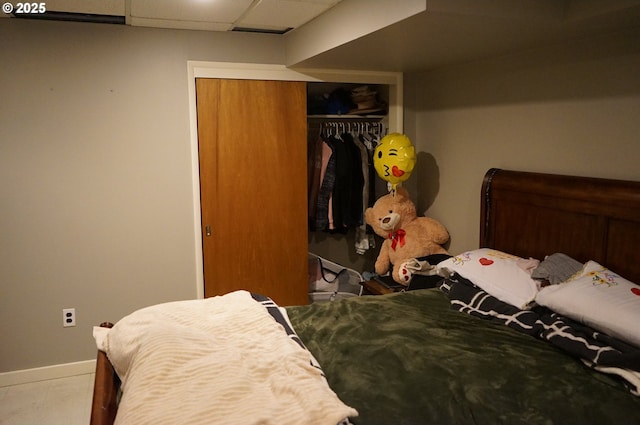 bedroom with a drop ceiling and a closet