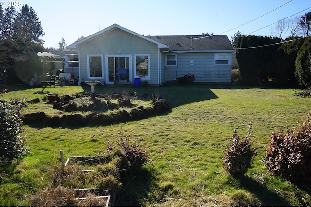 rear view of property with a yard