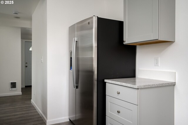 10304 SE Yukon St, Portland, OR 97266 - kitchen with stainless steel refrigerator with ice dispenser, baseboards, dark wood-style flooring, heating unit, and white cabinetry