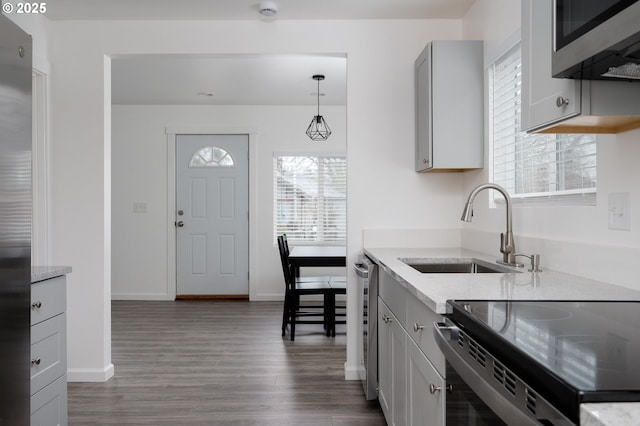 kitchen with sink, gray cabinetry, decorative light fixtures, appliances with stainless steel finishes, and a wealth of natural light