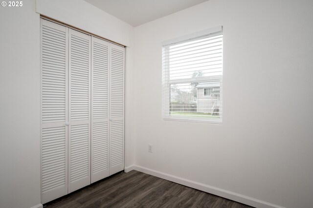 10304 SE Yukon St, Portland, OR 97266 - unfurnished bedroom with a closet, dark wood-style flooring, and baseboards