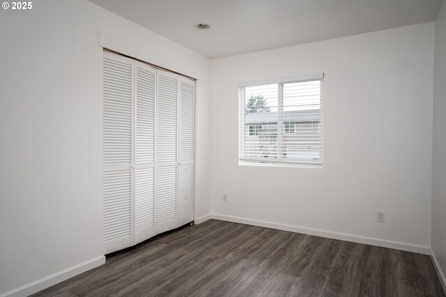 10304 SE Yukon St, Portland, OR 97266 - unfurnished bedroom featuring dark wood-type flooring, a closet, and baseboards