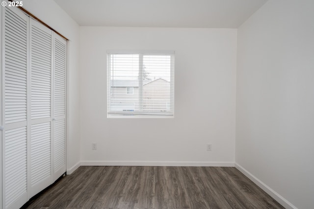 unfurnished bedroom featuring dark wood-type flooring and a closet